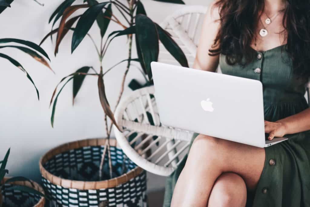 woman with a laptop on her lap for teletherapy session