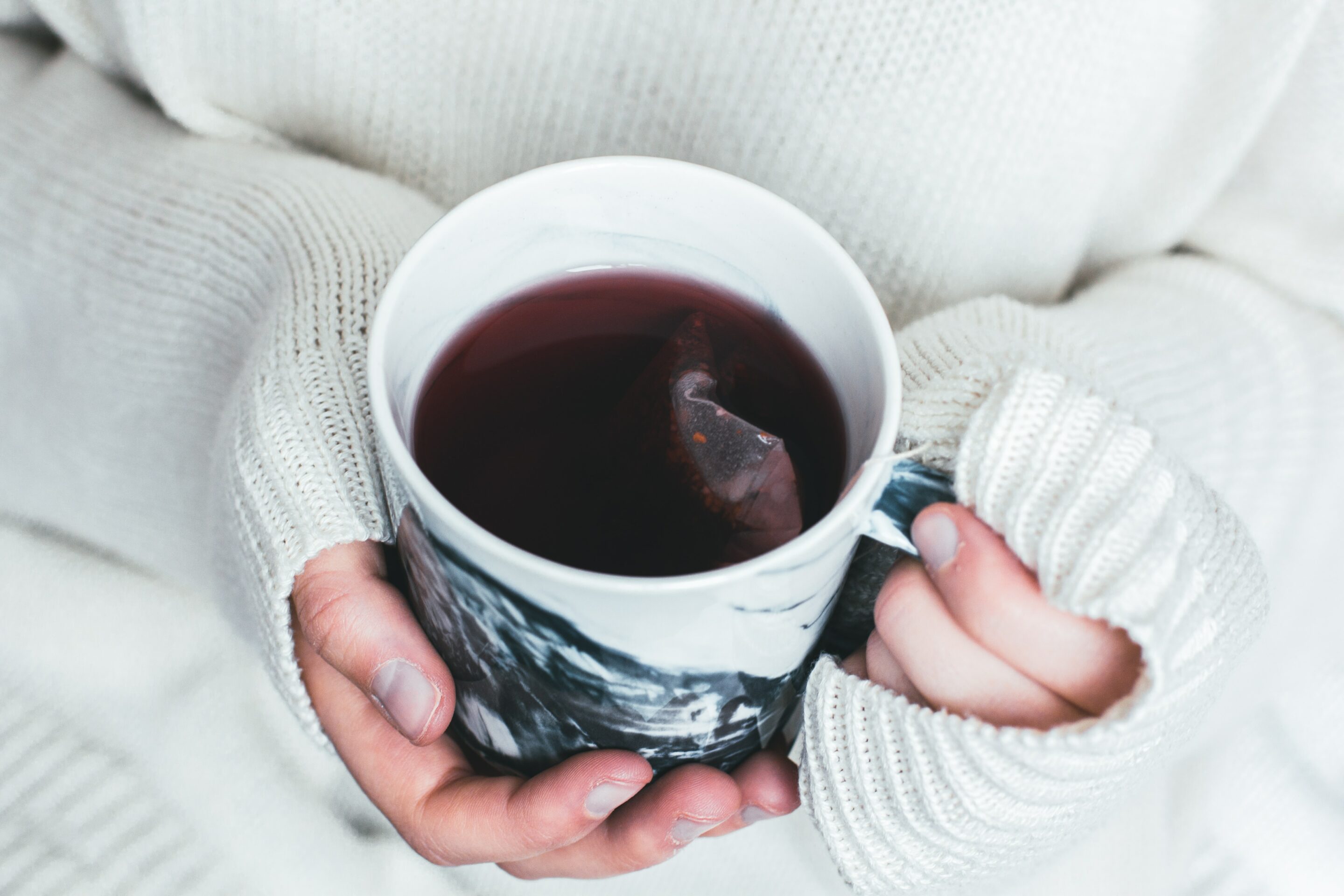 holding a cup of hot tea